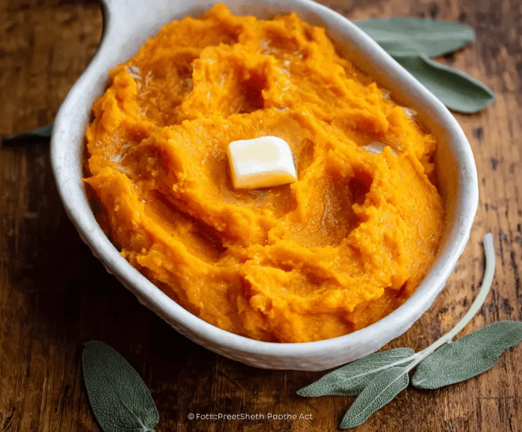 Creamy mashed butternut squash served in a bowl, garnished with fresh herbs for a comforting fall side dish.