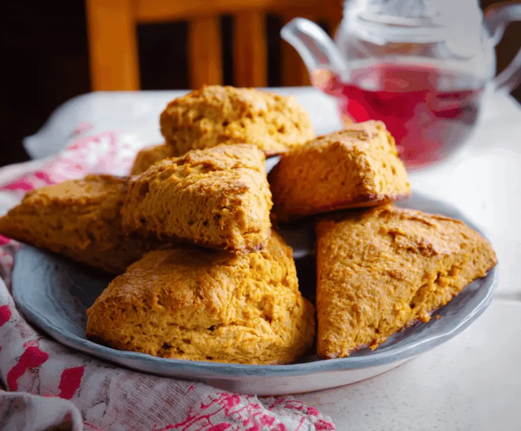 Delicious homemade sweet potato scones on a plate, showcasing golden-brown crust and soft interior, perfect for breakfast or snack.