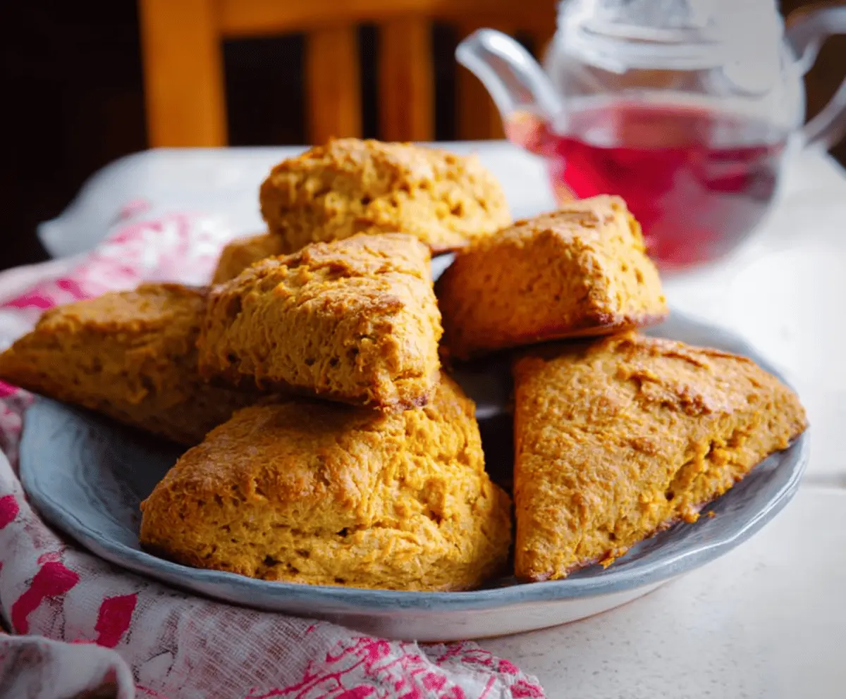 Delicious homemade sweet potato scones on a plate, showcasing golden-brown crust and soft interior, perfect for breakfast or snack.