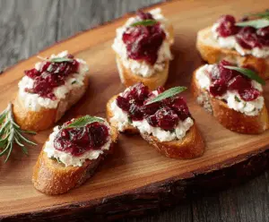 Delicious Goat Cheese and Cranberry Crostini served on a wooden platter.