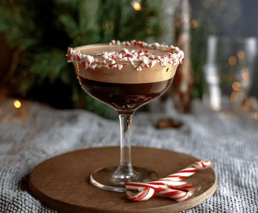 Delicious Peppermint Mocha Martini garnished with mint leaves and chocolate shavings on a festive tray.