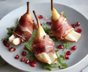 Prosciutto wrapped pears appetizer with fresh herbs and honey drizzle.