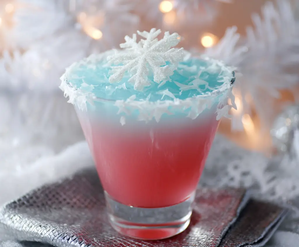 Festive Christmas Snowflake Cocktail with sparkling garnish in a clear glass.