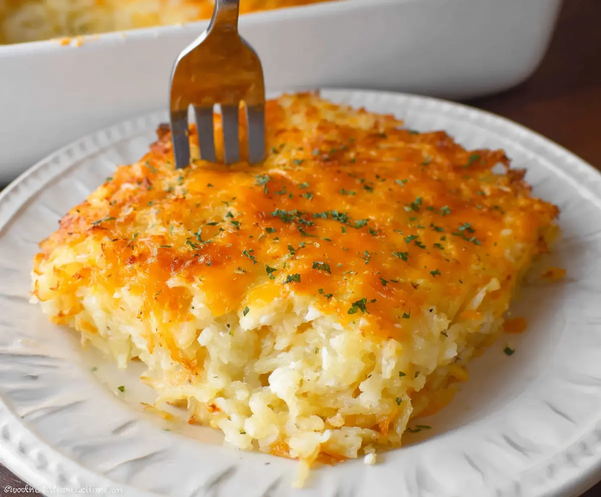 Delicious Cracker Barrel Hashbrown Casserole with melted cheese and crispy toppings on a serving plate.