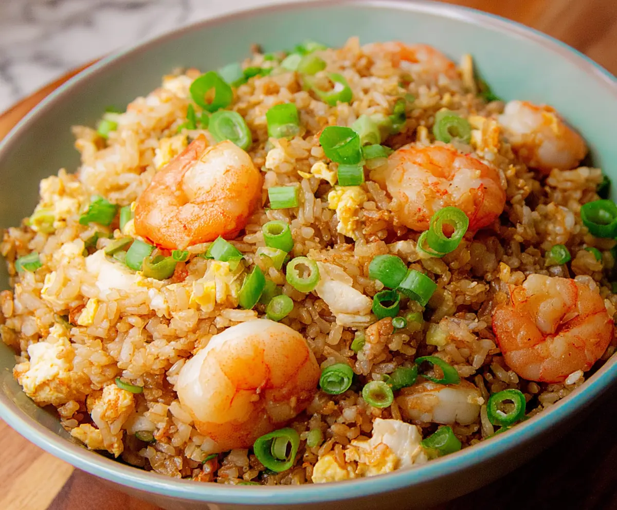 Delicious shrimp garlic fried rice served in a bowl, garnished with chopped green onions.