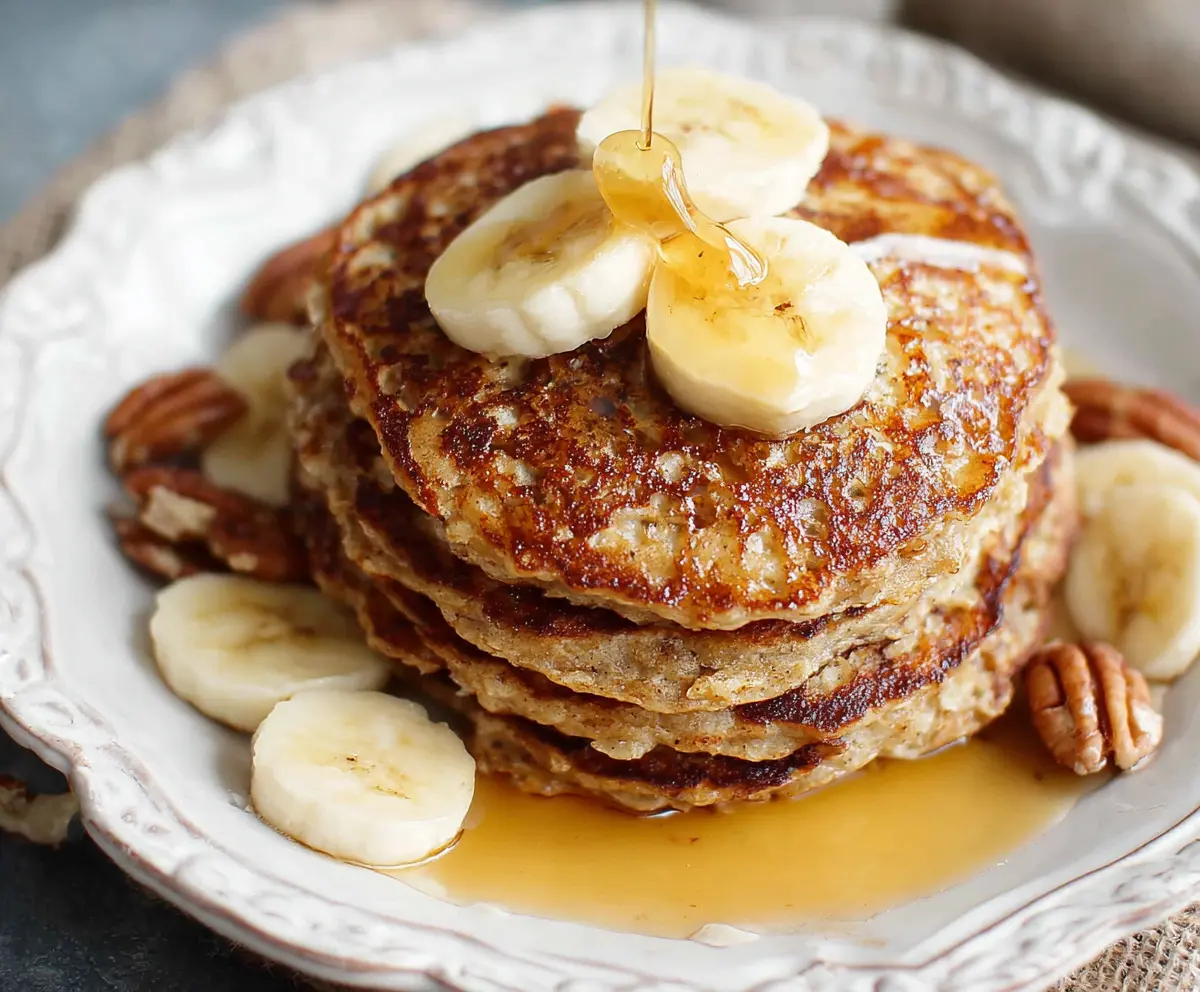 Delicious homemade banana oatmeal pancakes served on a plate with fresh fruit.