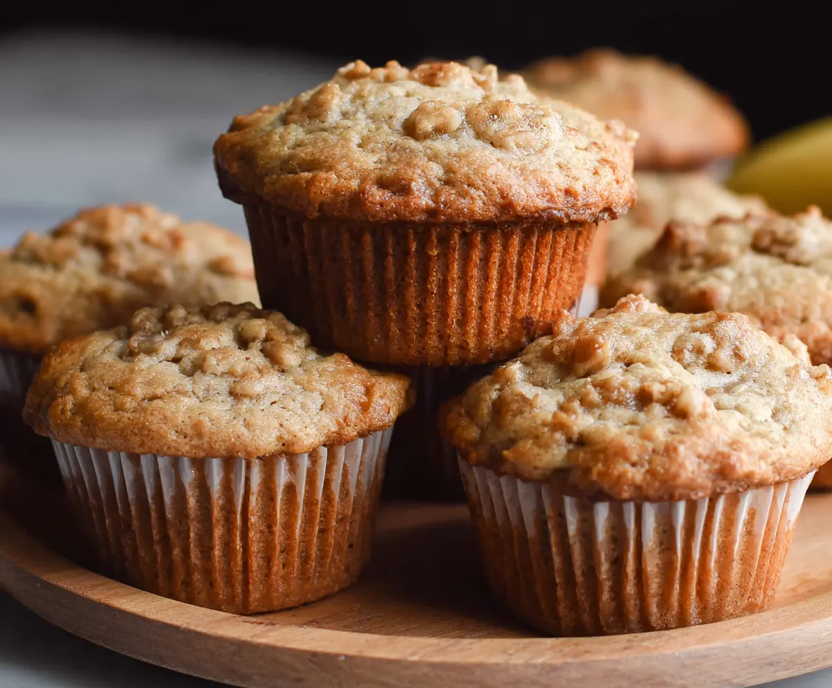 Delicious homemade sourdough banana muffins on a rustic plate with ripe bananas in the background