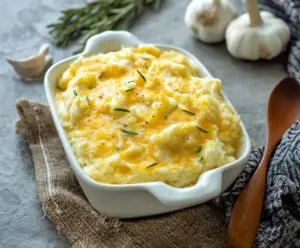 Creamy cheesy garlic mashed potatoes served in a rustic bowl, perfect for comfort food lovers.