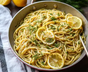 Creamy browned butter lemon dill pasta garnished with fresh herbs on a white plate