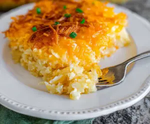Delicious cheesy hashbrown potato casserole topped with melted cheese and crispy edges.