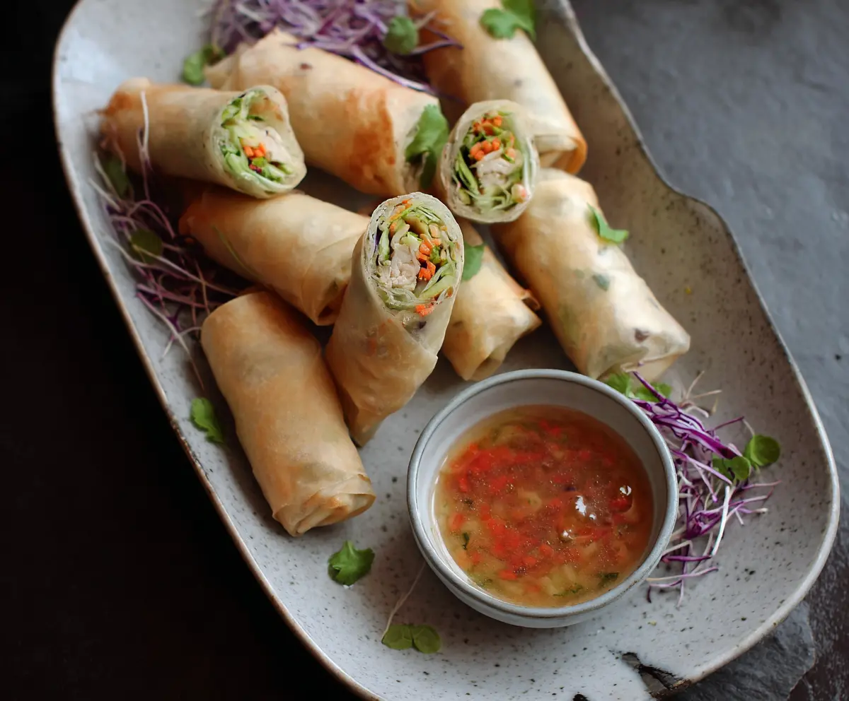 Delicious homemade chicken vegetable spring rolls served with dipping sauce