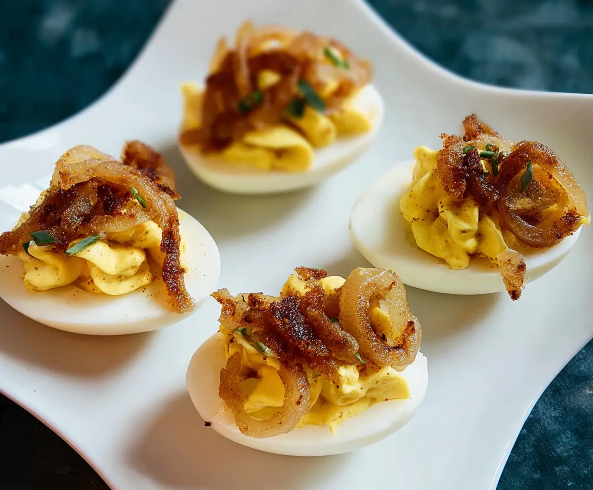 Creamy French Onion Deviled Eggs garnished with caramelized onions and fresh herbs.